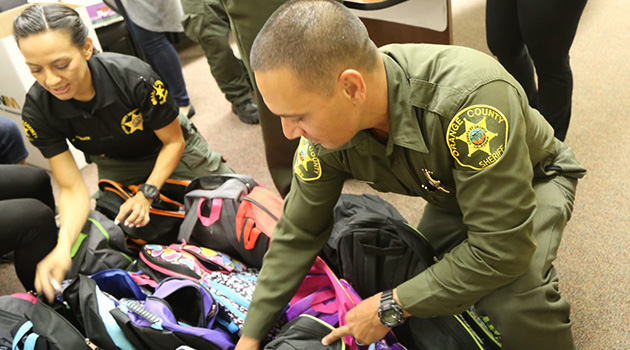 Two officers sorting through backpacks