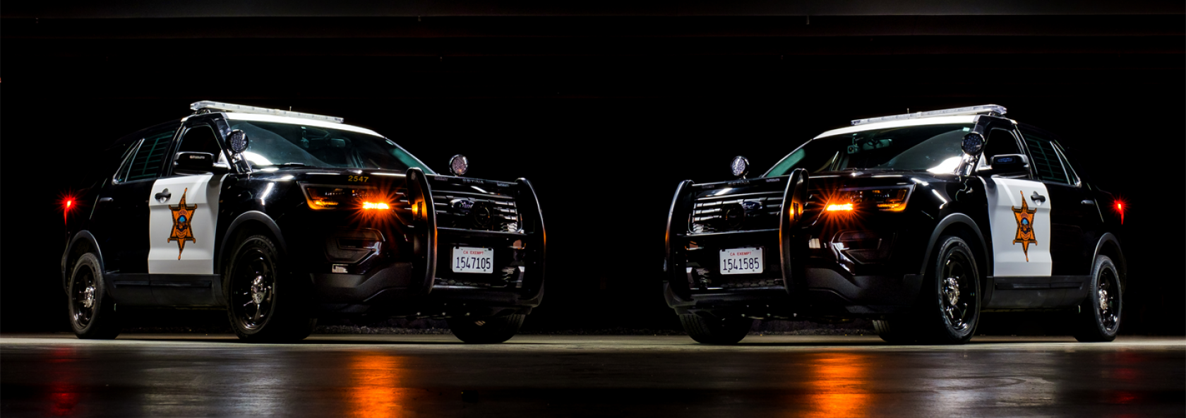 Two Sheriff patrol SUV's on black background