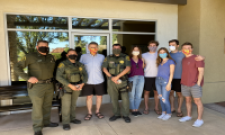 Officers pose with family of rescued Olympic swimmer